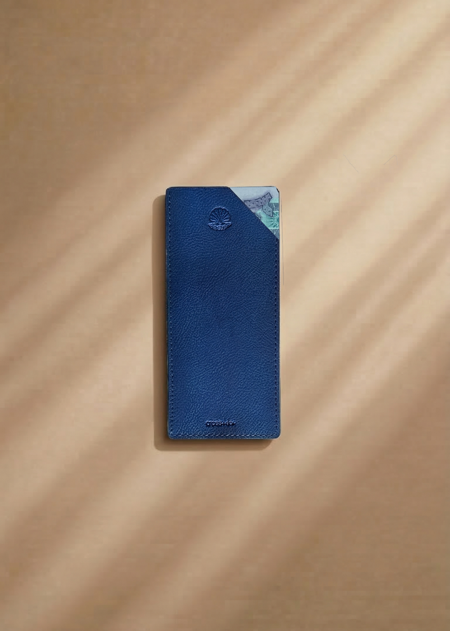 Blue leather money envelope with a pearl shell debossed on a beige surface