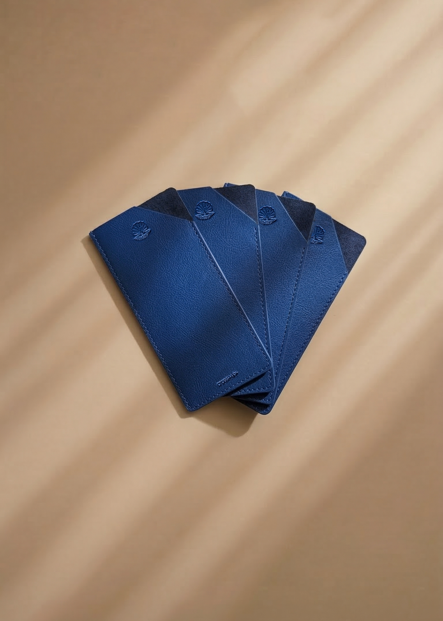 Blue leather stacked on a beige surface with soft shadows