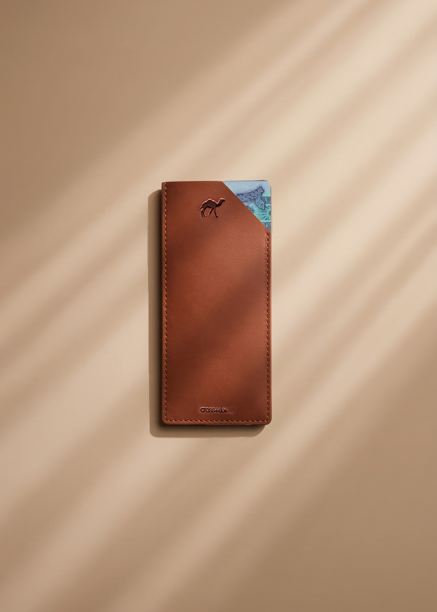 Brown leather money envelope with a camel debossed on a beige background