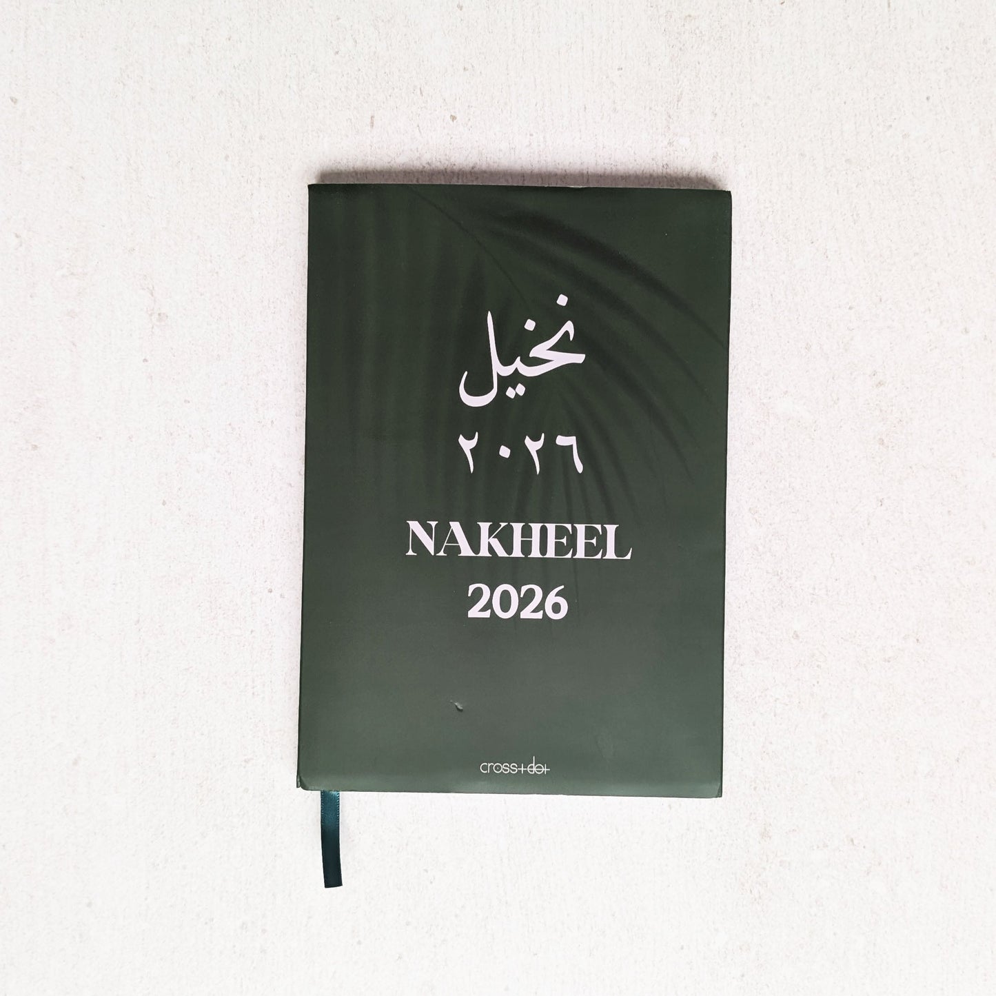 Green notebook with 'Nakheel 2026' text on a white background