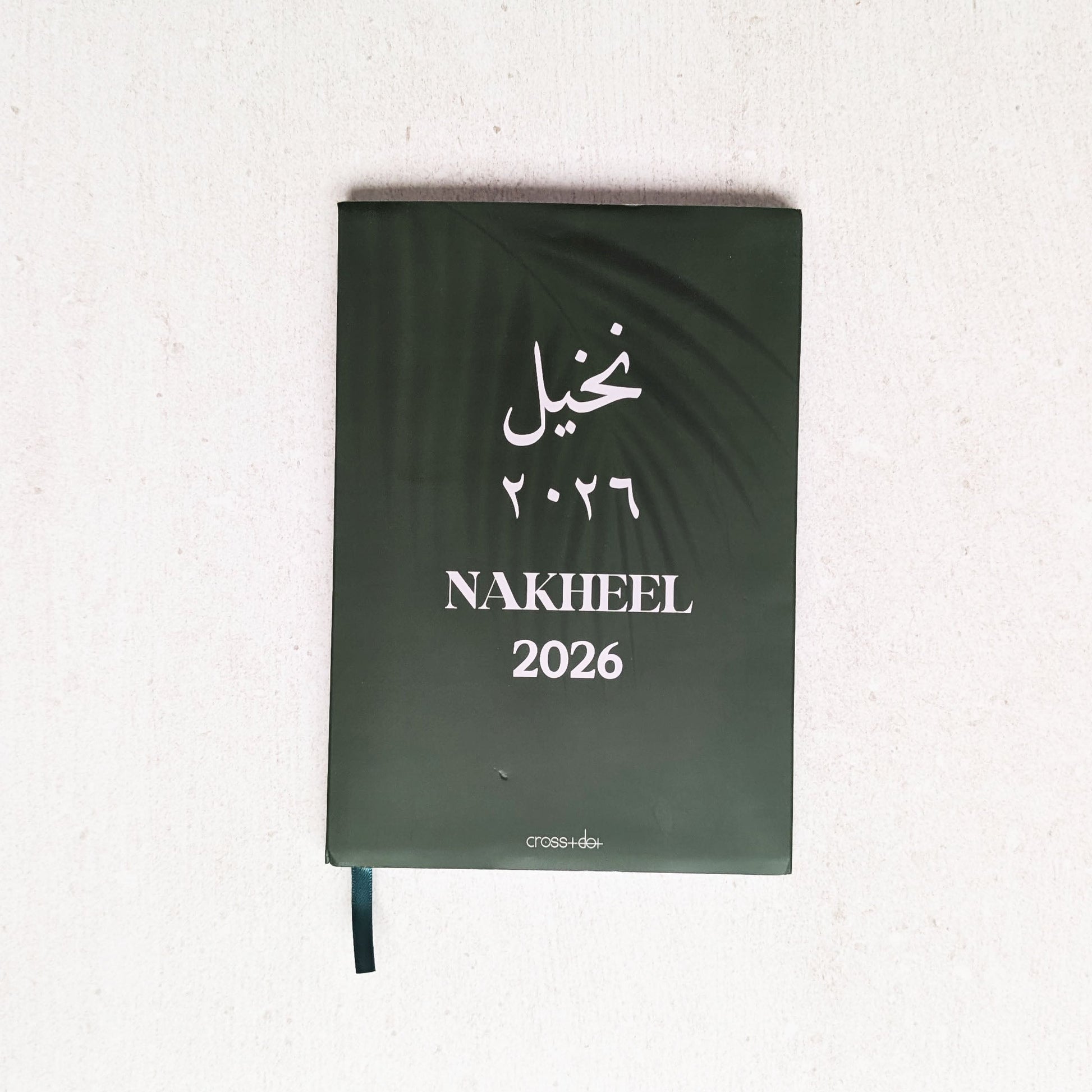 Green notebook with 'Nakheel 2026' text on a white background