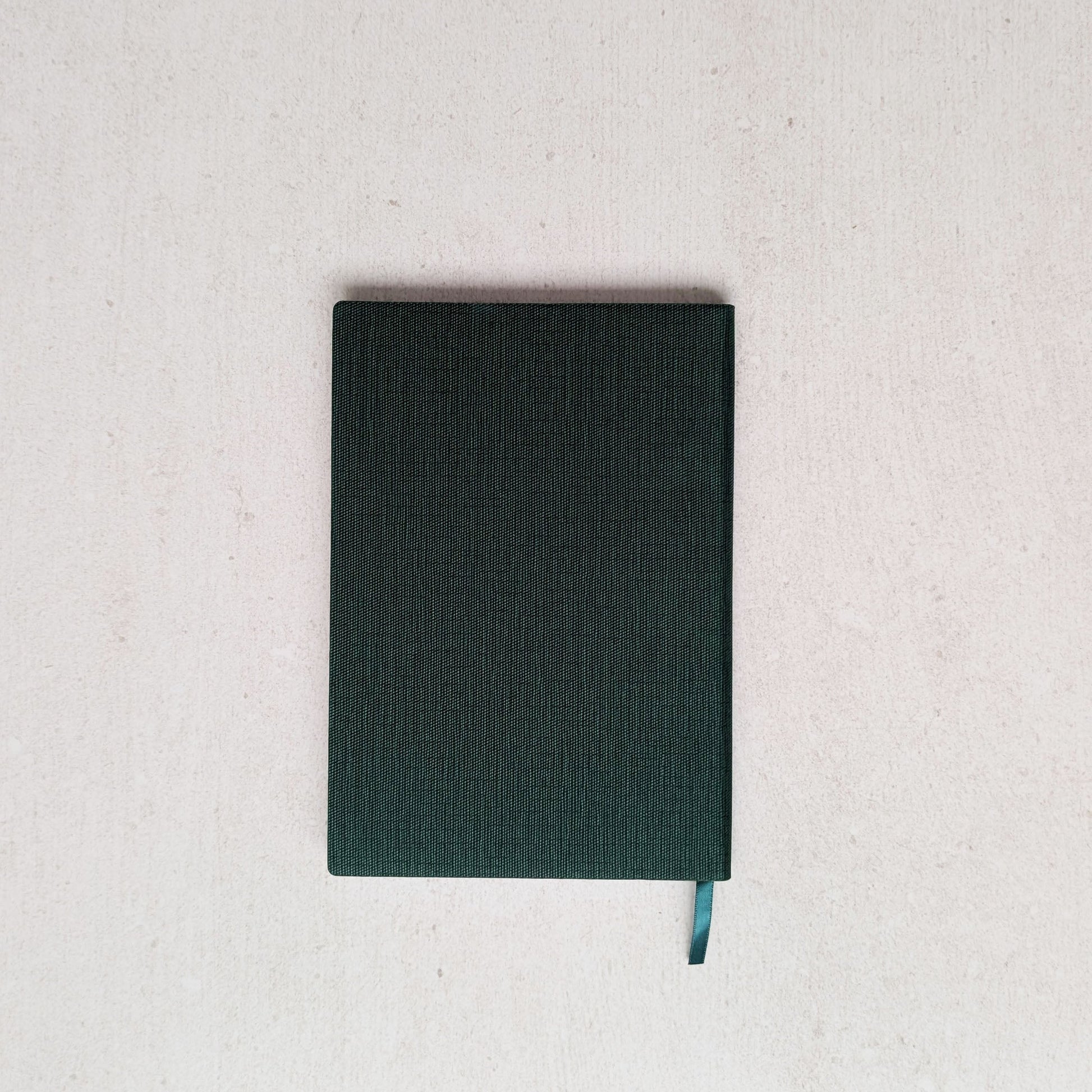 Dark green notebook on a light gray background