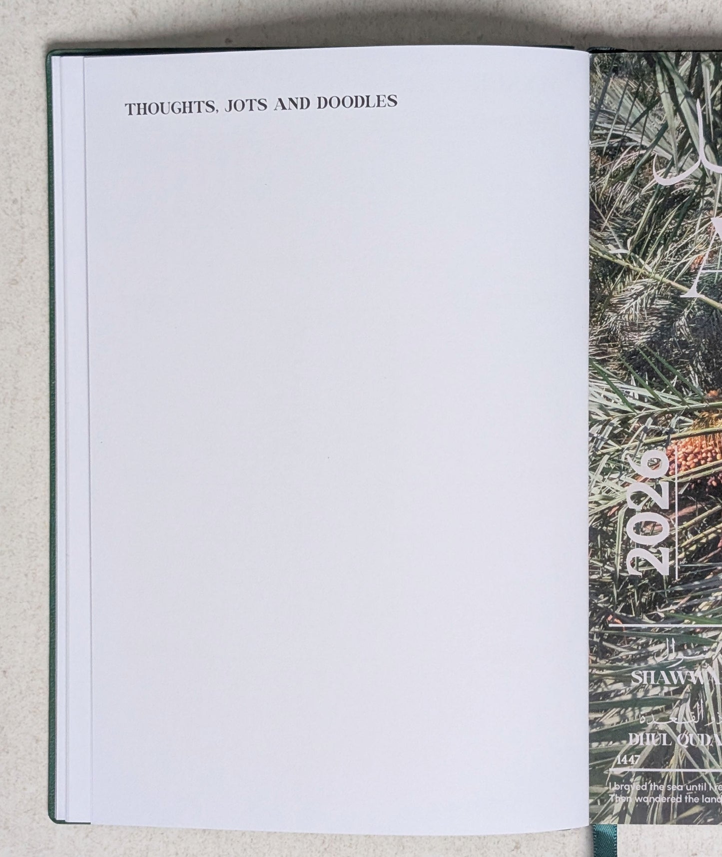 Open notebook with a page titled 'Thoughts, Jots and Doodles' on a textured surface